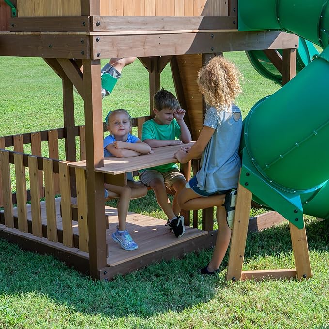 Backyard Discovery Skyfort All Cedar Swing Set, Elevated Covered Wood Roof Clubhouse with Bay Windows, 2 Belt Swings, Web Swing, 10ft Wave Slide, 5 ft Tube Slide, Covered Picnic Table, 5 ft Rock Wall